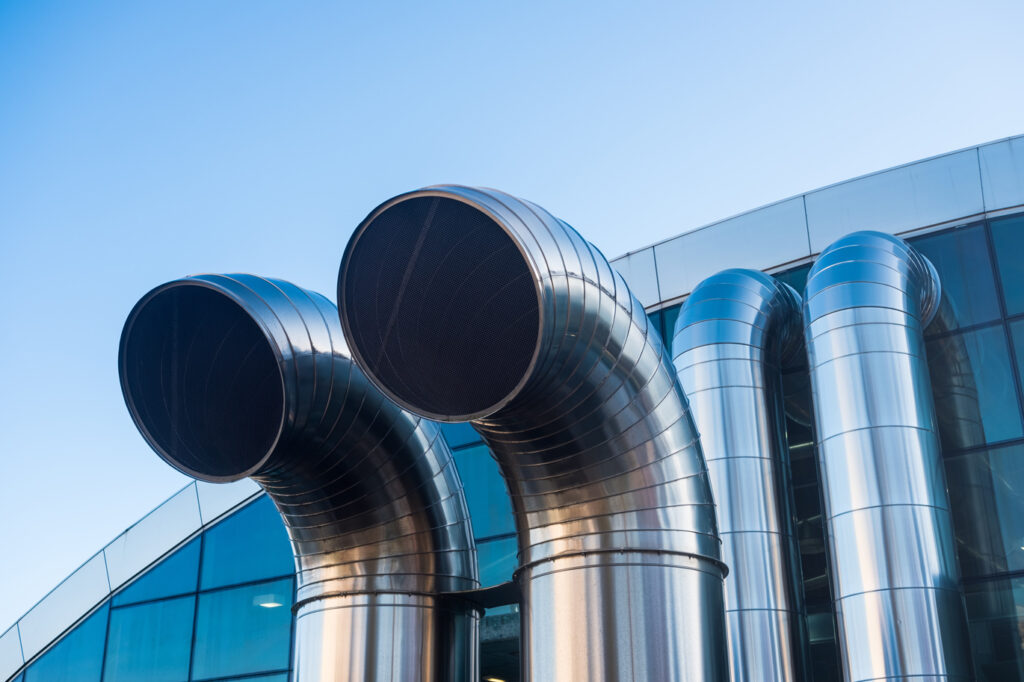 Funnel ventilation ducts on a modern building, blue sky